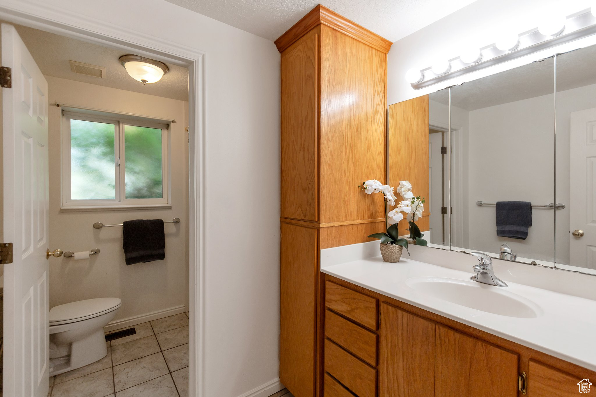 Bathroom with vanity, toilet, and tile patterned flooring