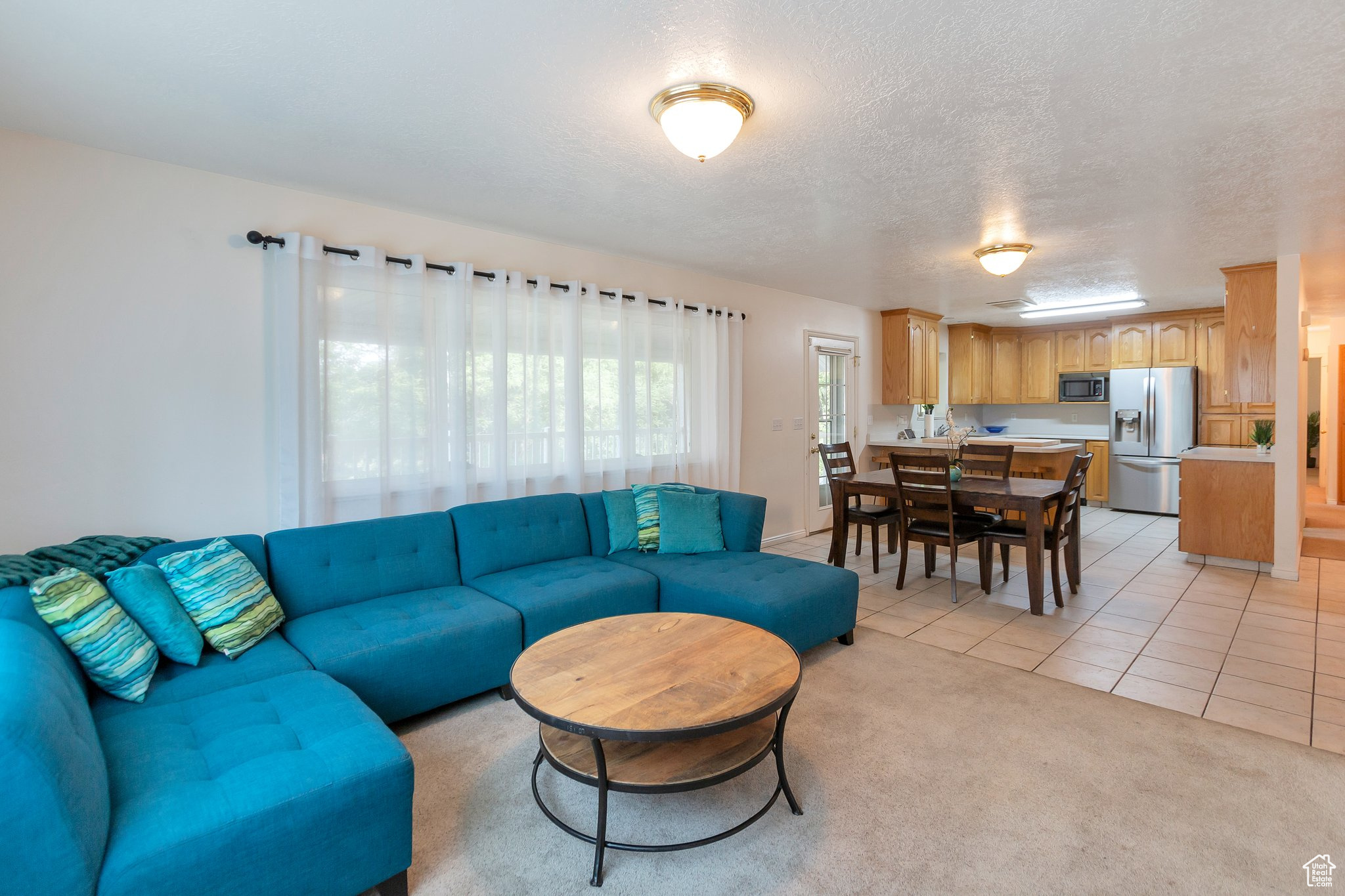 Carpeted living room with a textured ceiling