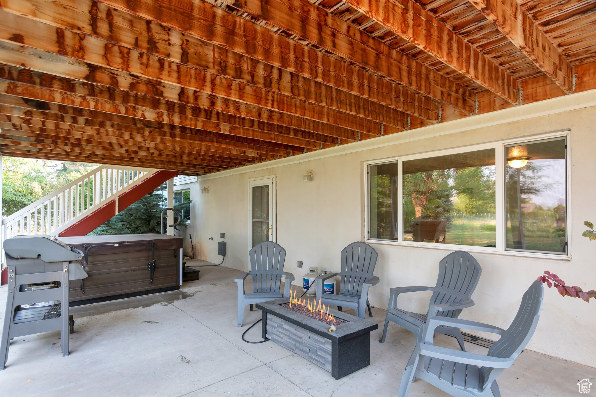 View of patio featuring a hot tub and a fire pit