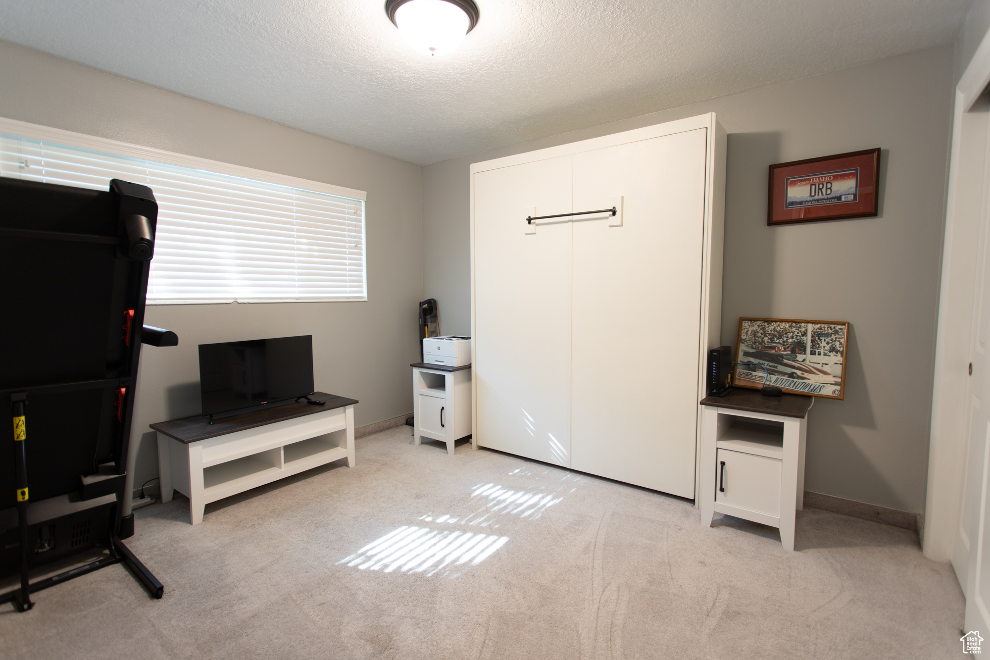 Interior space with a textured ceiling and light carpet