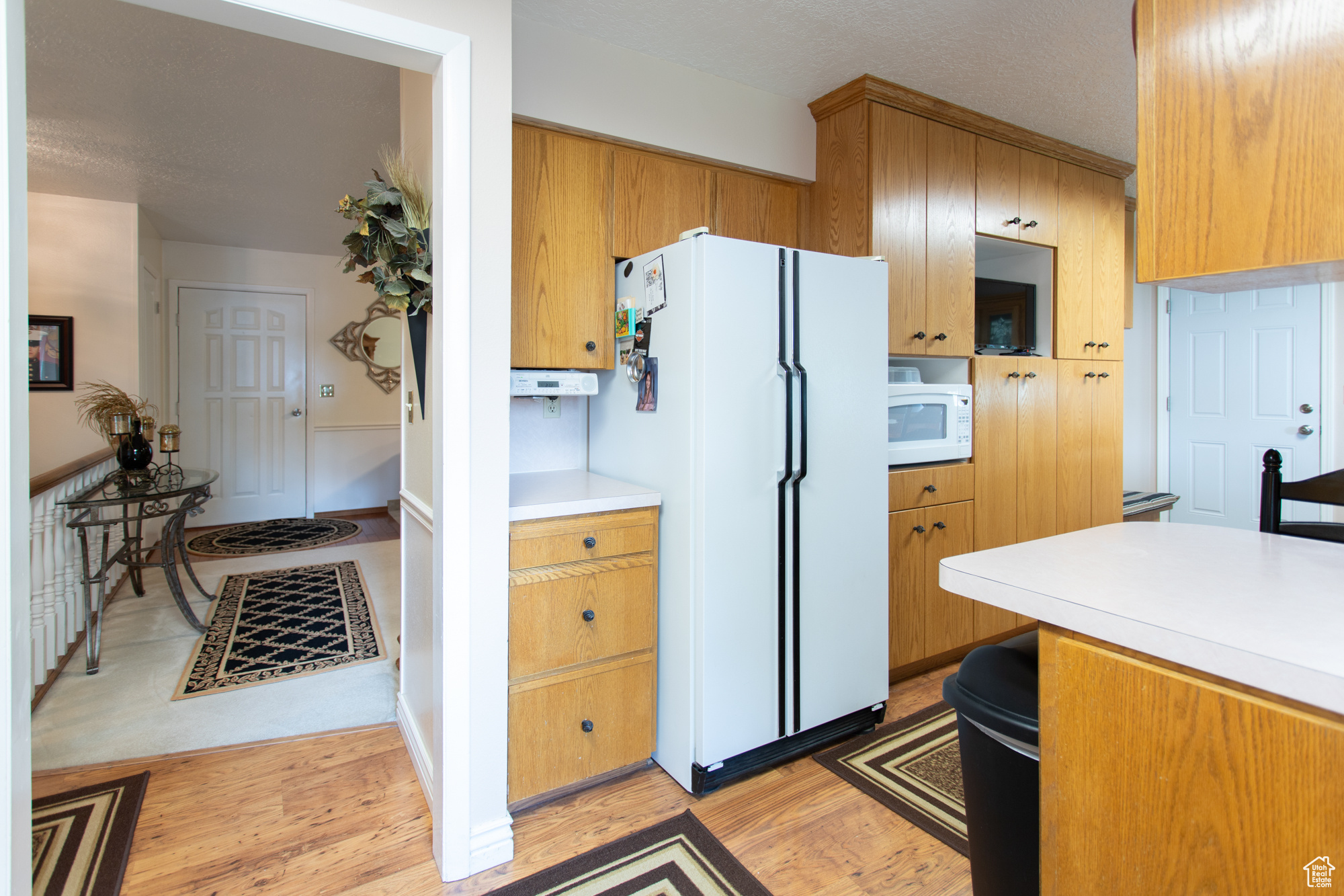 Kitchen featuring light wood-type flooring and white appliances