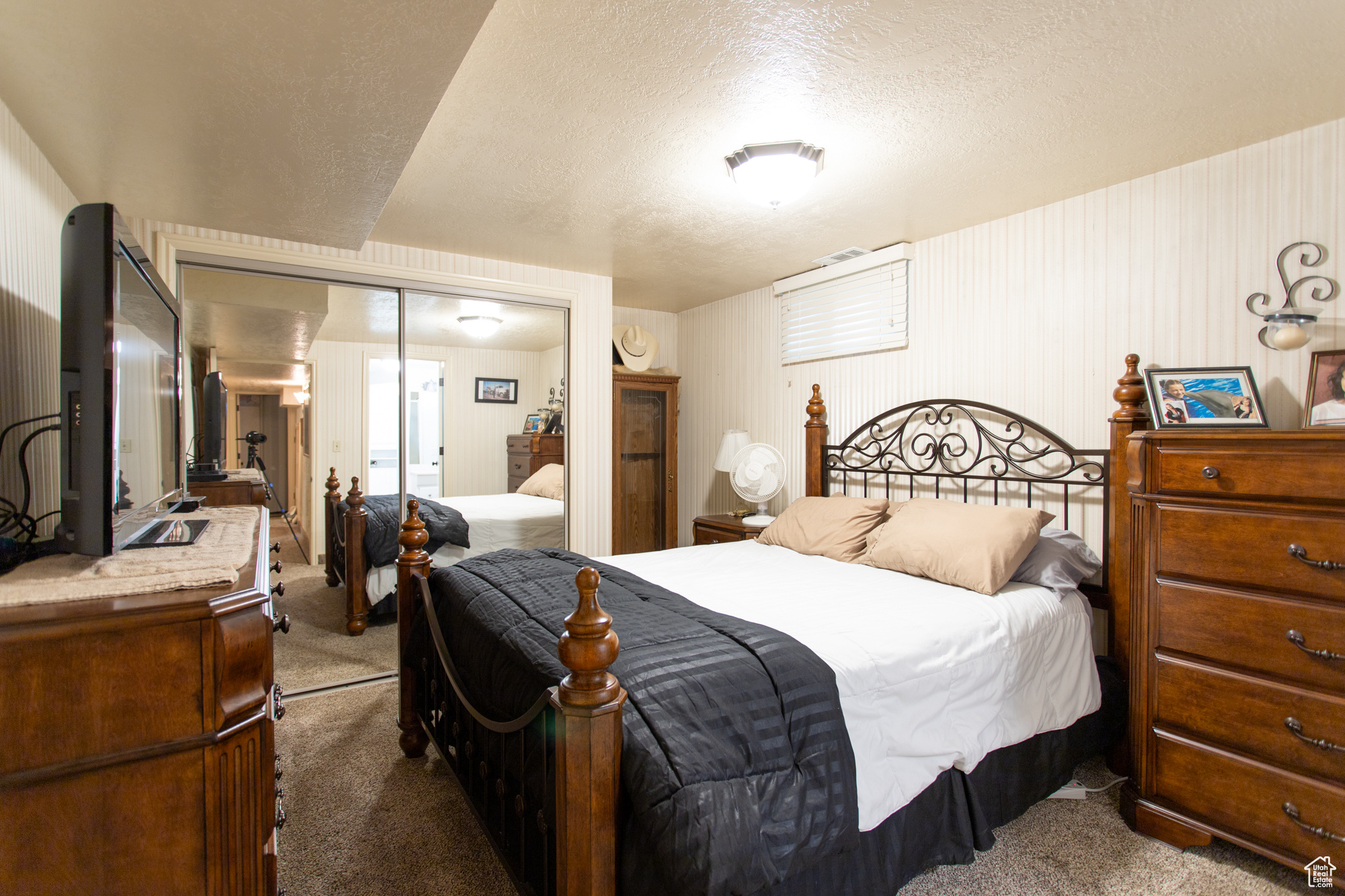 Bedroom with a textured ceiling, carpet, and a closet