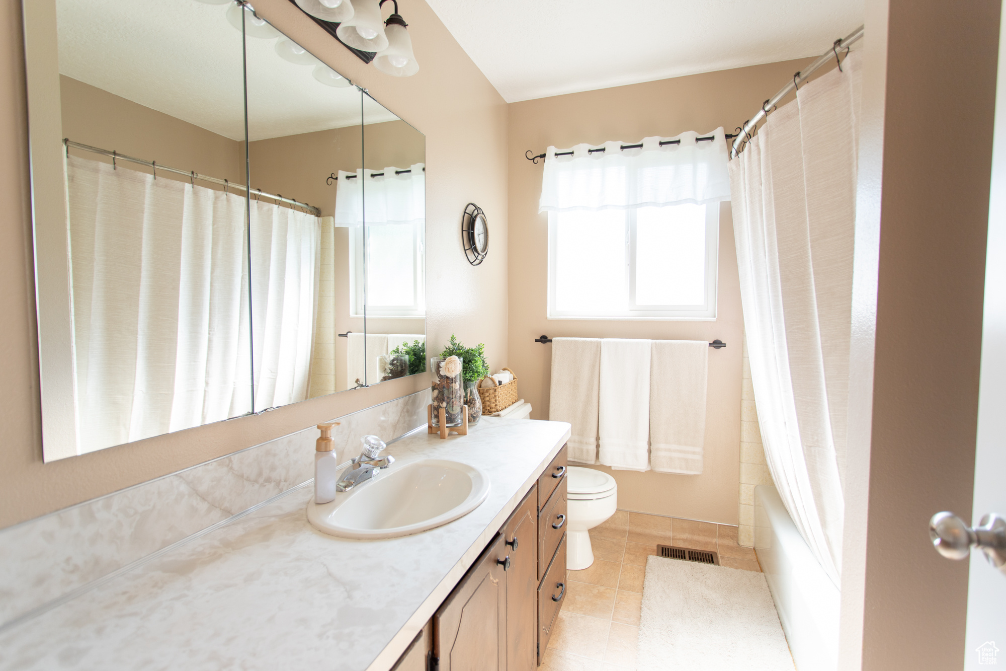 Full bathroom featuring shower / bath combo, tile patterned floors, vanity, and toilet