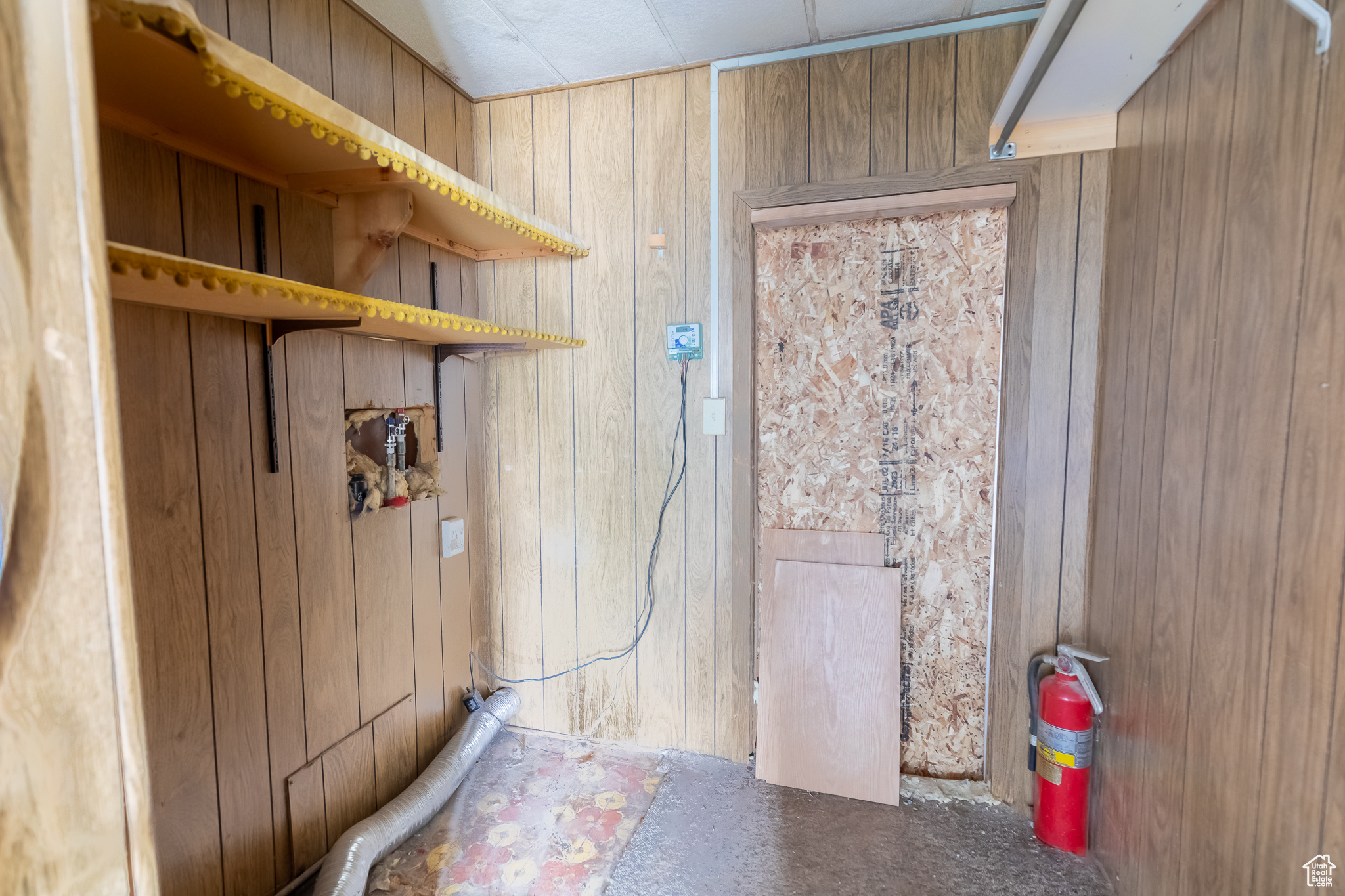 Laundry room with wooden walls