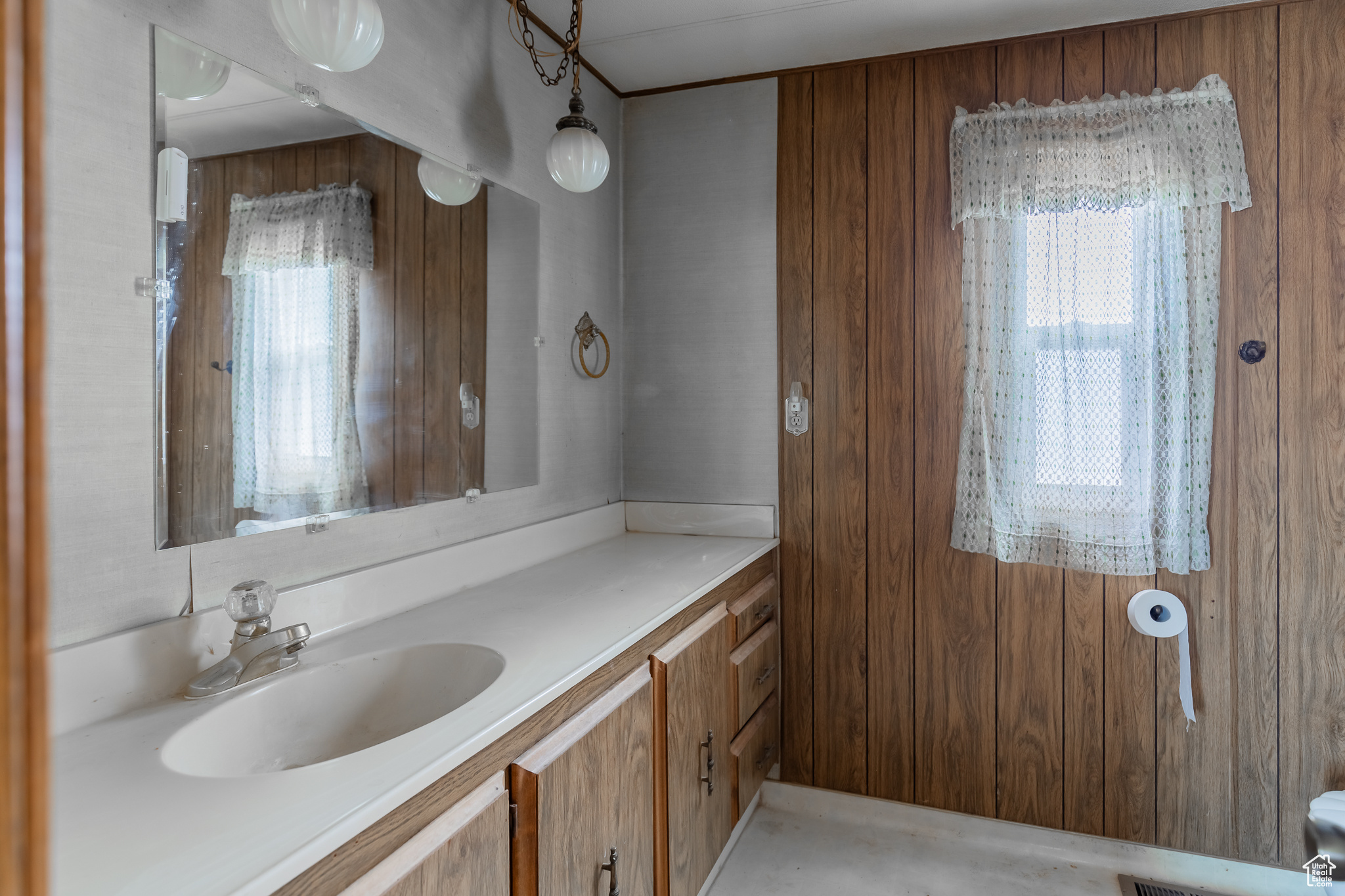 Bathroom featuring wooden walls and a healthy amount of sunlight