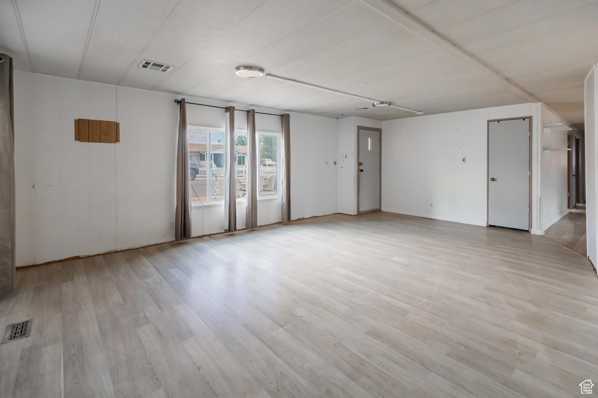 Empty room with light hardwood / wood-style flooring