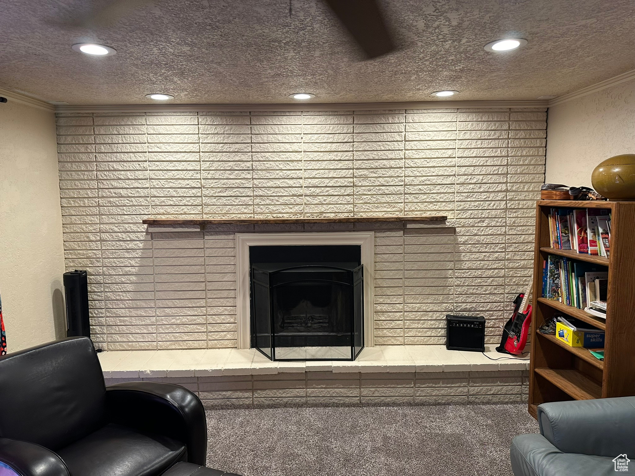 Living room featuring can lighting, original wood-burning brick fireplace