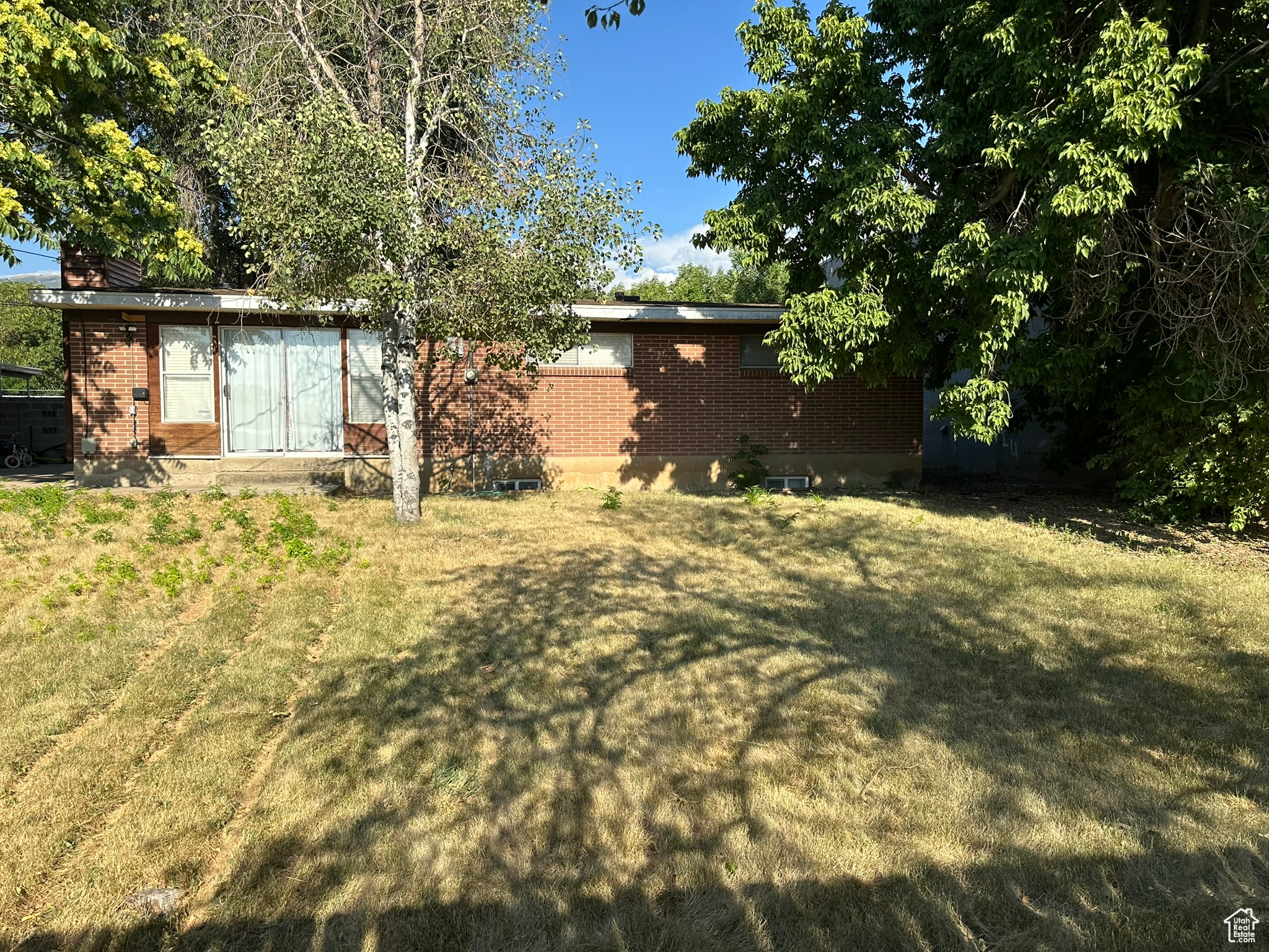 View of the back of the house from backyard featuring sliding glass door to living room