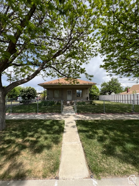 View of front facade featuring covered porch and a front lawn