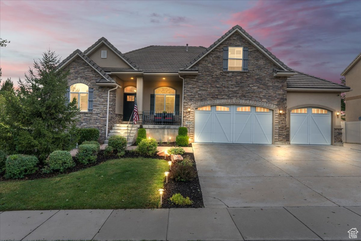 View of front of property with a yard and a garage