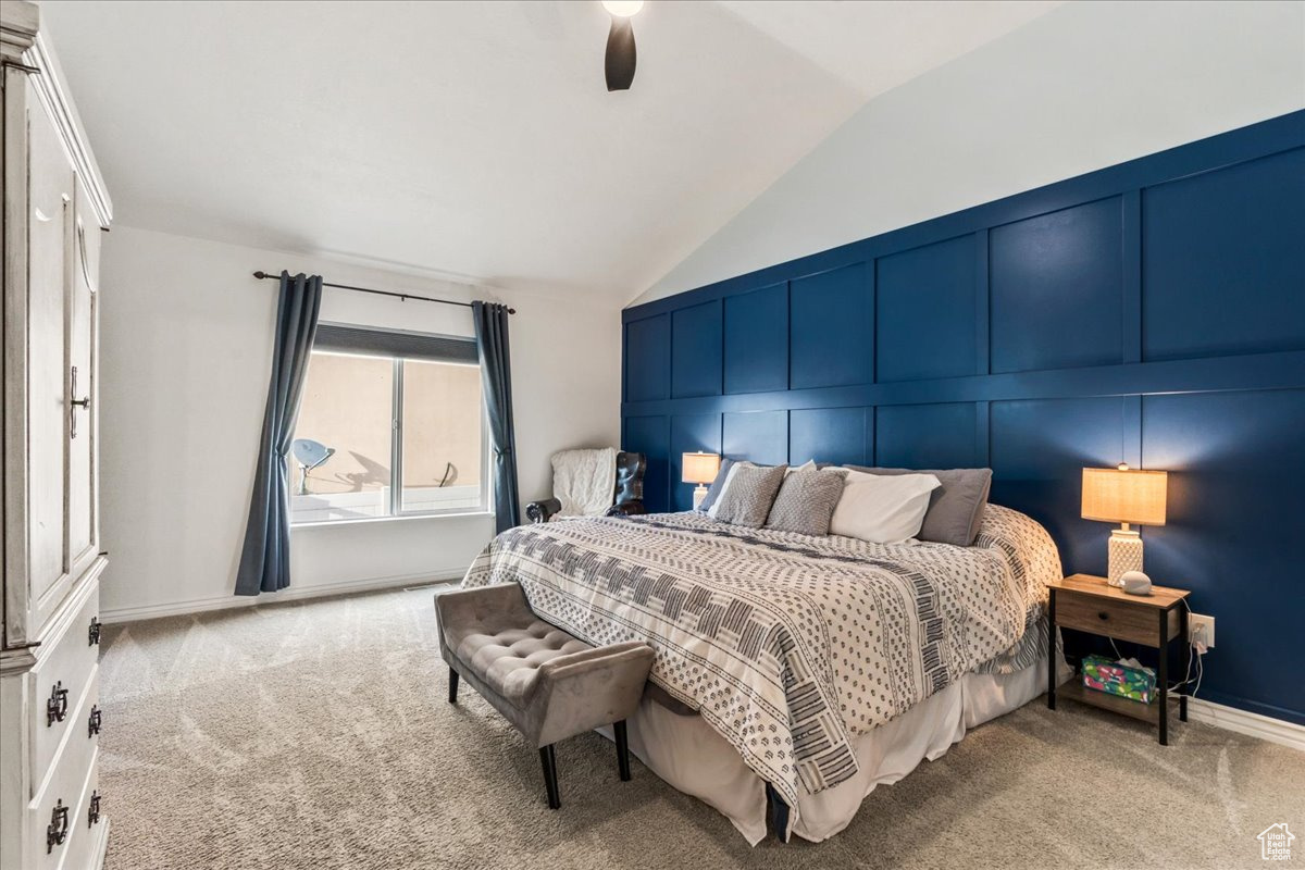 Carpeted bedroom featuring lofted ceiling and ceiling fan