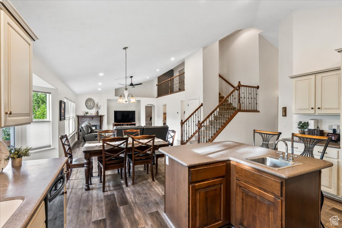 Kitchen with sink, dark hardwood / wood-style flooring, cream cabinets, and a kitchen island