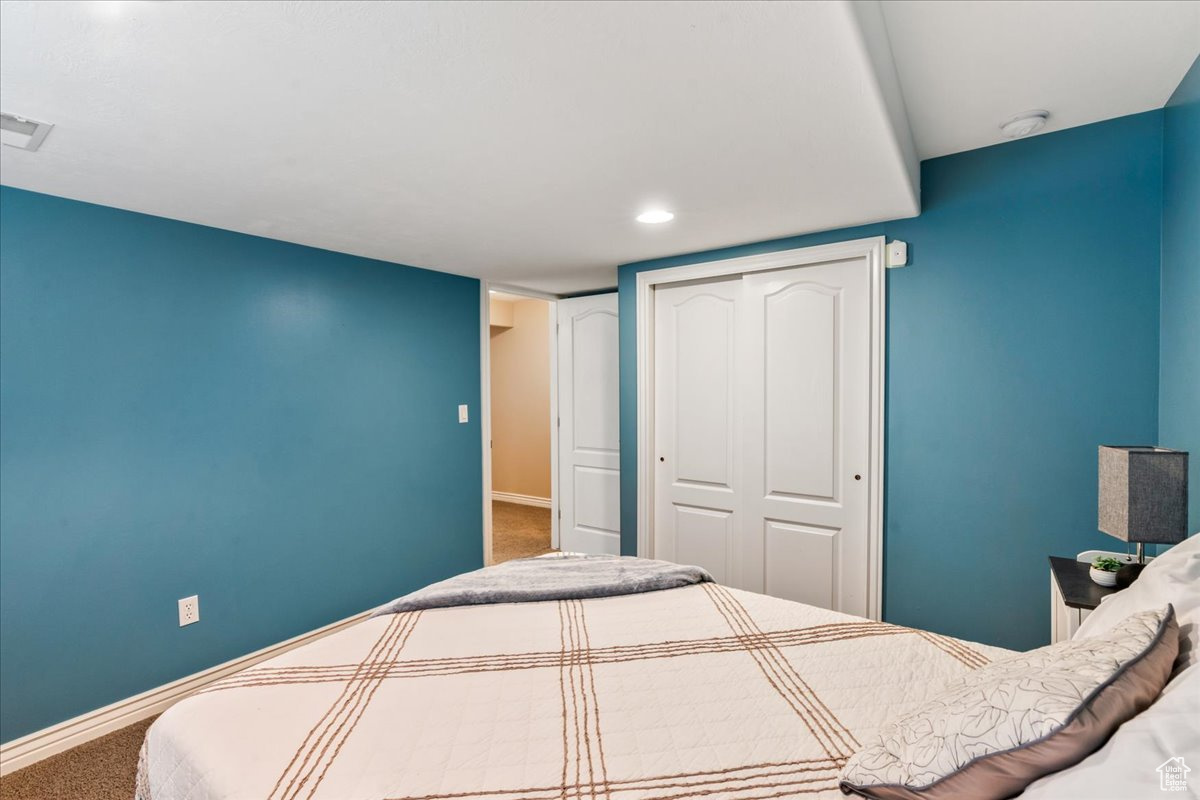 Carpeted bedroom featuring a closet