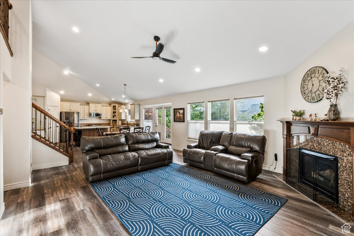 Living room featuring a high end fireplace, ceiling fan, high vaulted ceiling, and hardwood / wood-style flooring