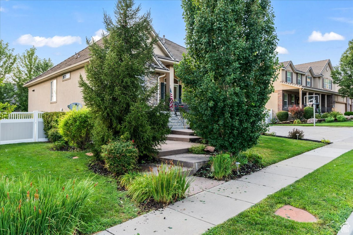 Obstructed view of property featuring a balcony and a front lawn