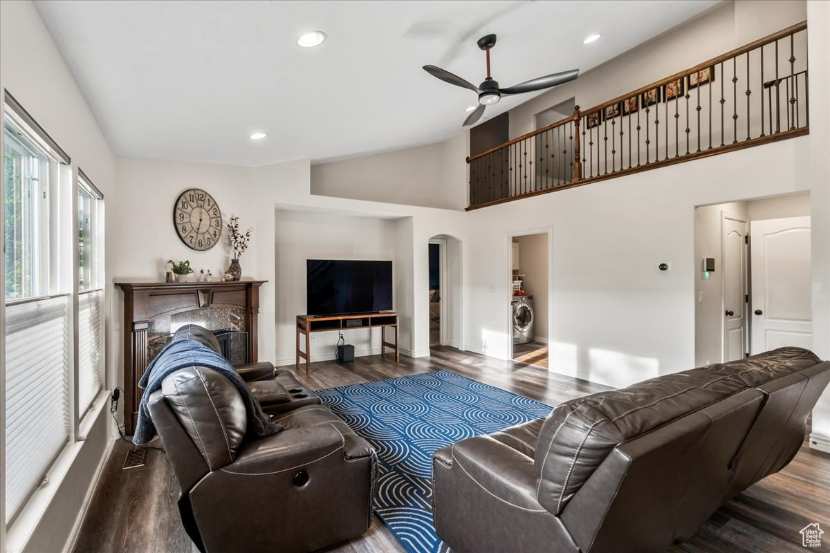 Living room with high vaulted ceiling, dark hardwood / wood-style floors, and ceiling fan