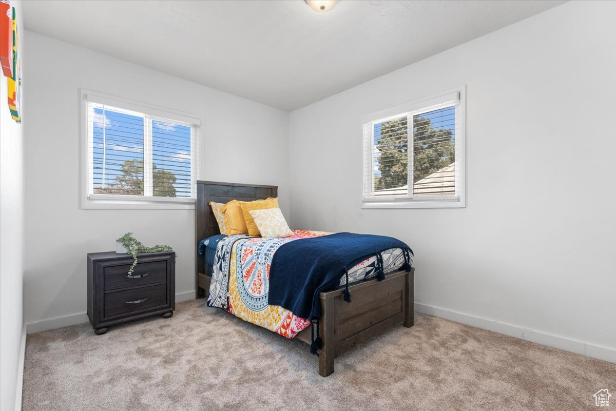 Bedroom featuring light carpet