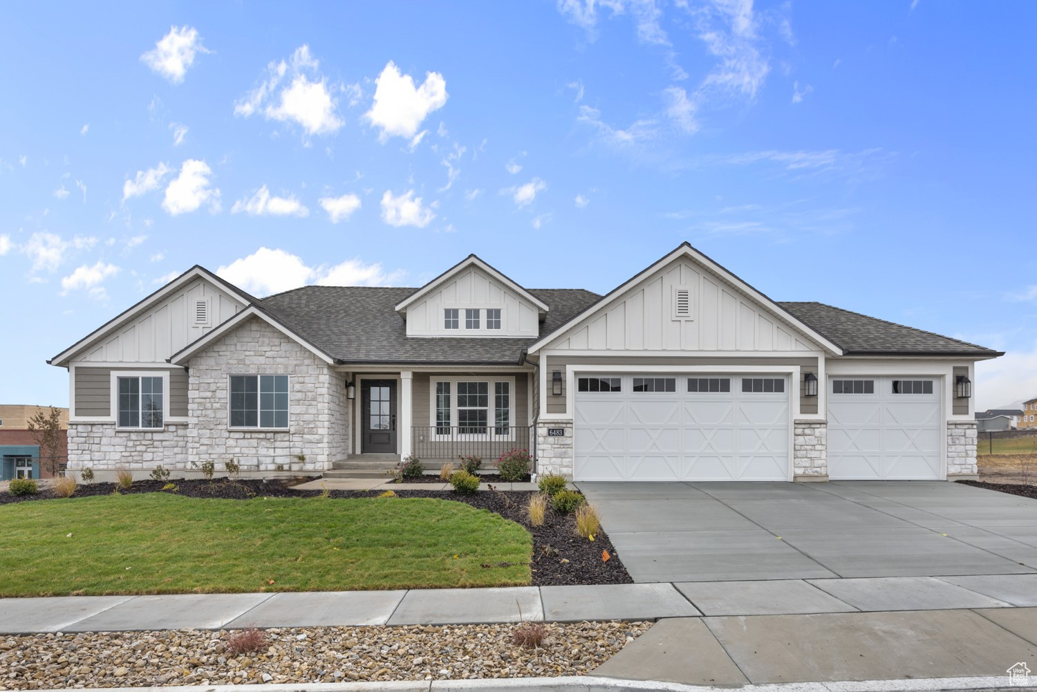 Craftsman inspired home featuring a garage and a front lawn