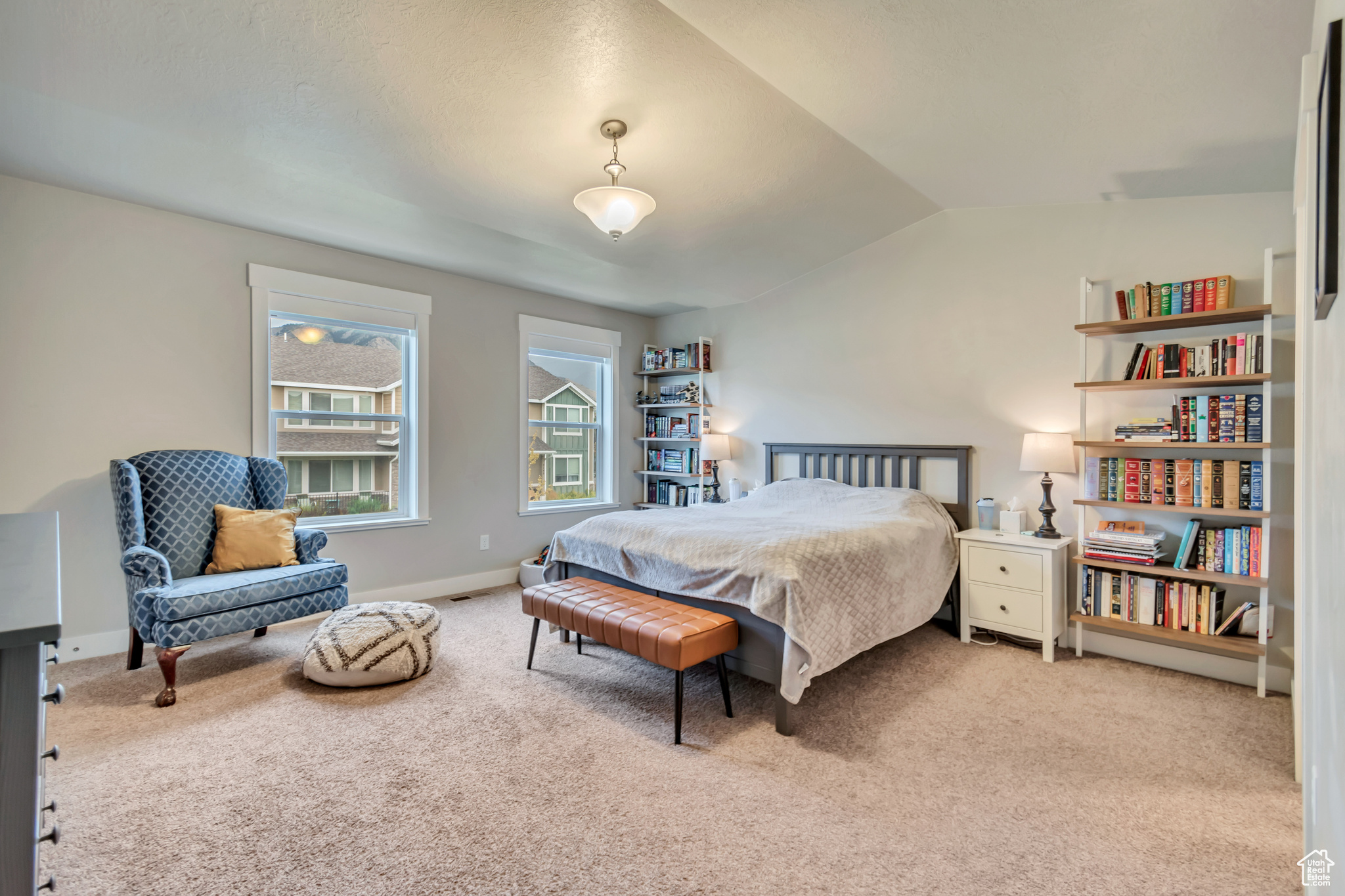 Bedroom with light colored carpet and vaulted ceiling