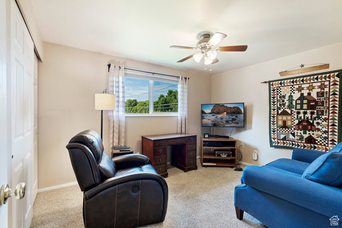 Living room with ceiling fan and light colored carpet