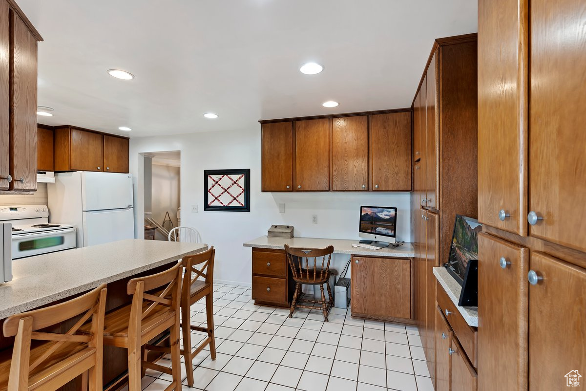 Kitchen with white appliances and light tile patterned flooring