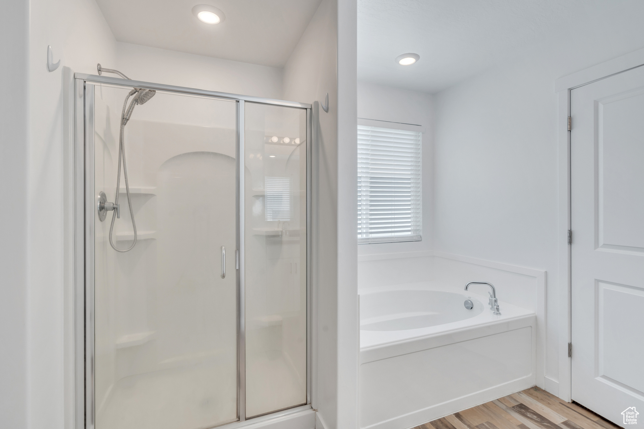 Bathroom featuring separate shower and tub and wood-type flooring