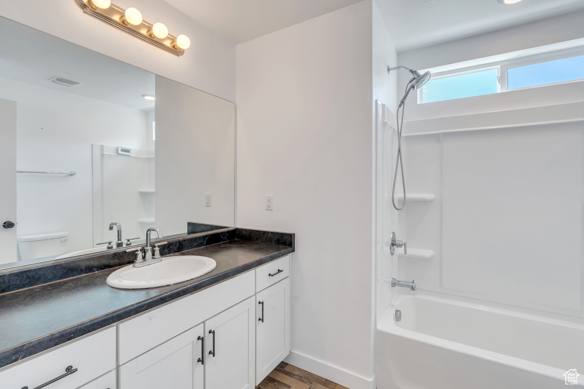 Full bathroom with shower / bath combination, toilet, and vanity