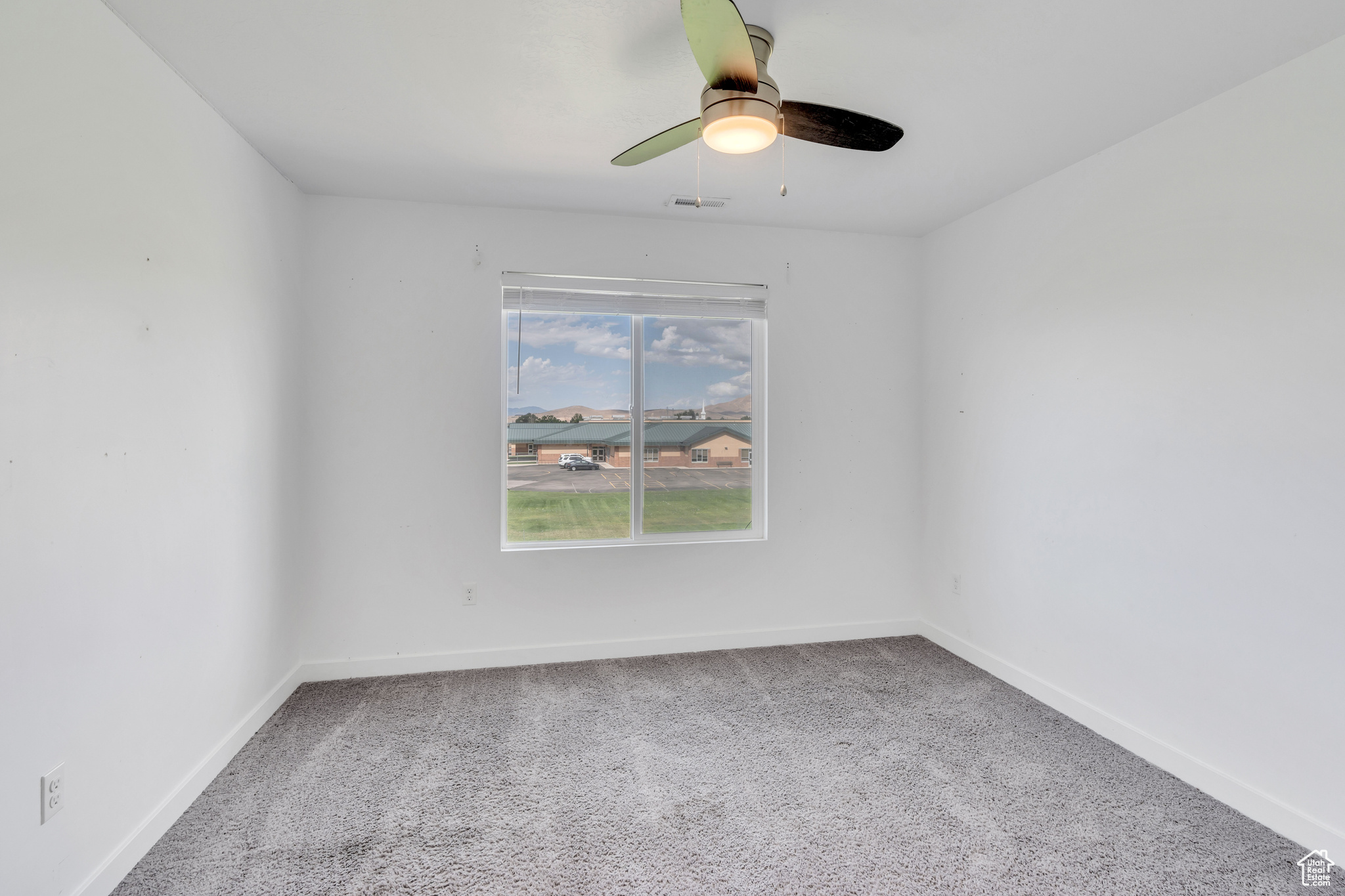 Unfurnished room with ceiling fan and carpet