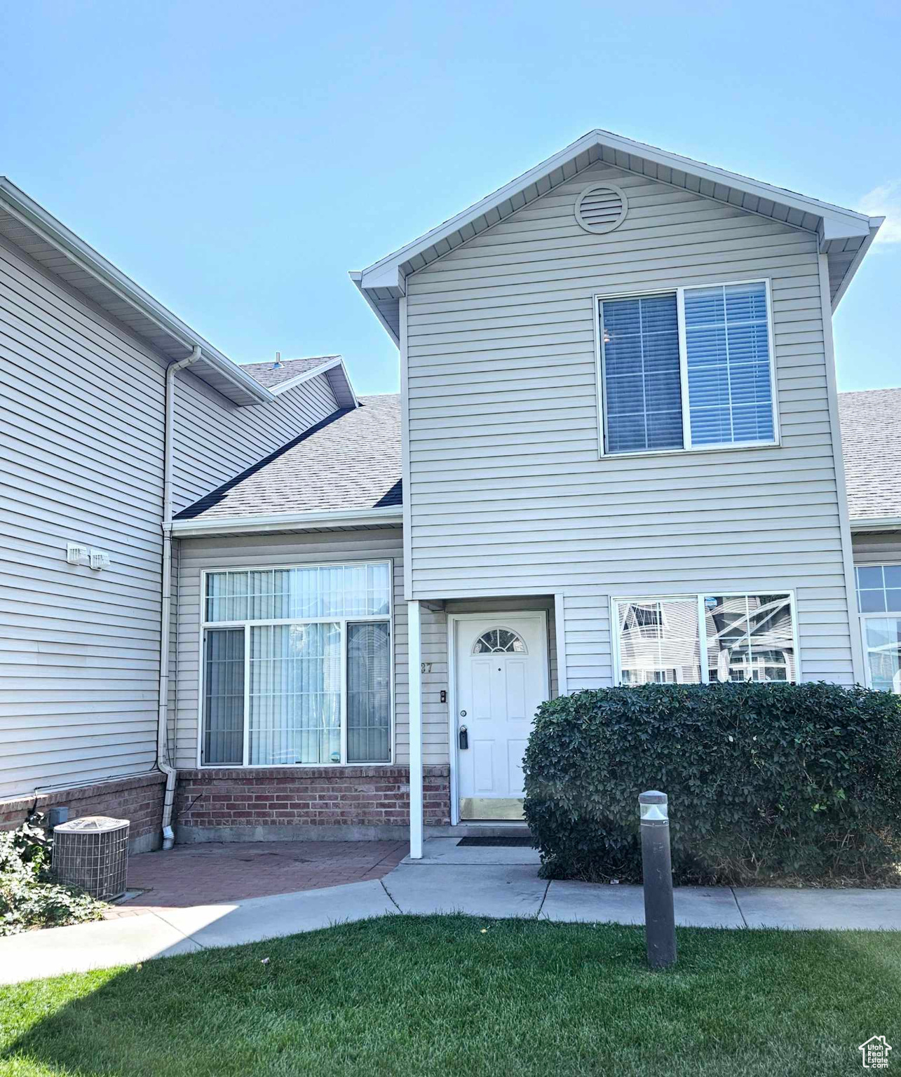 View of front of home featuring a front lawn and central air condition unit