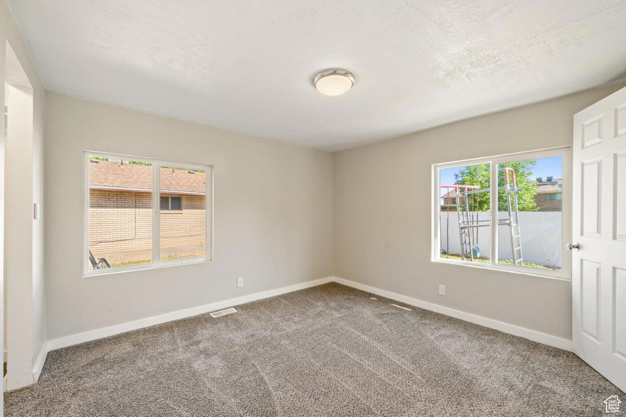 Spare room featuring carpet and a textured ceiling