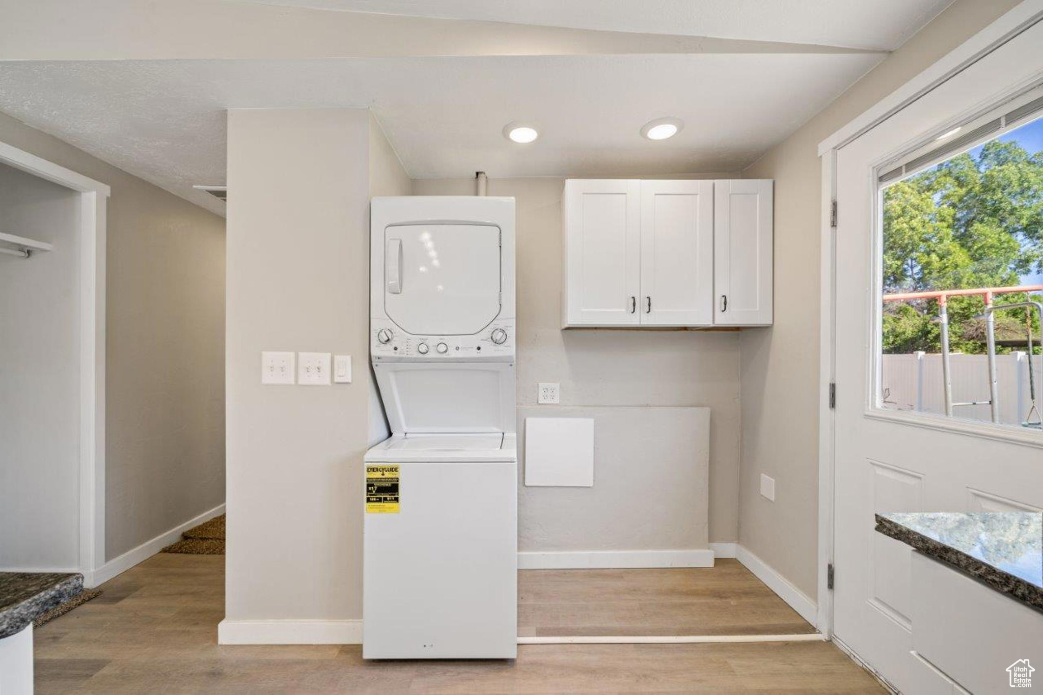 Laundry area featuring light hardwood / wood-style flooring and stacked washer and dryer