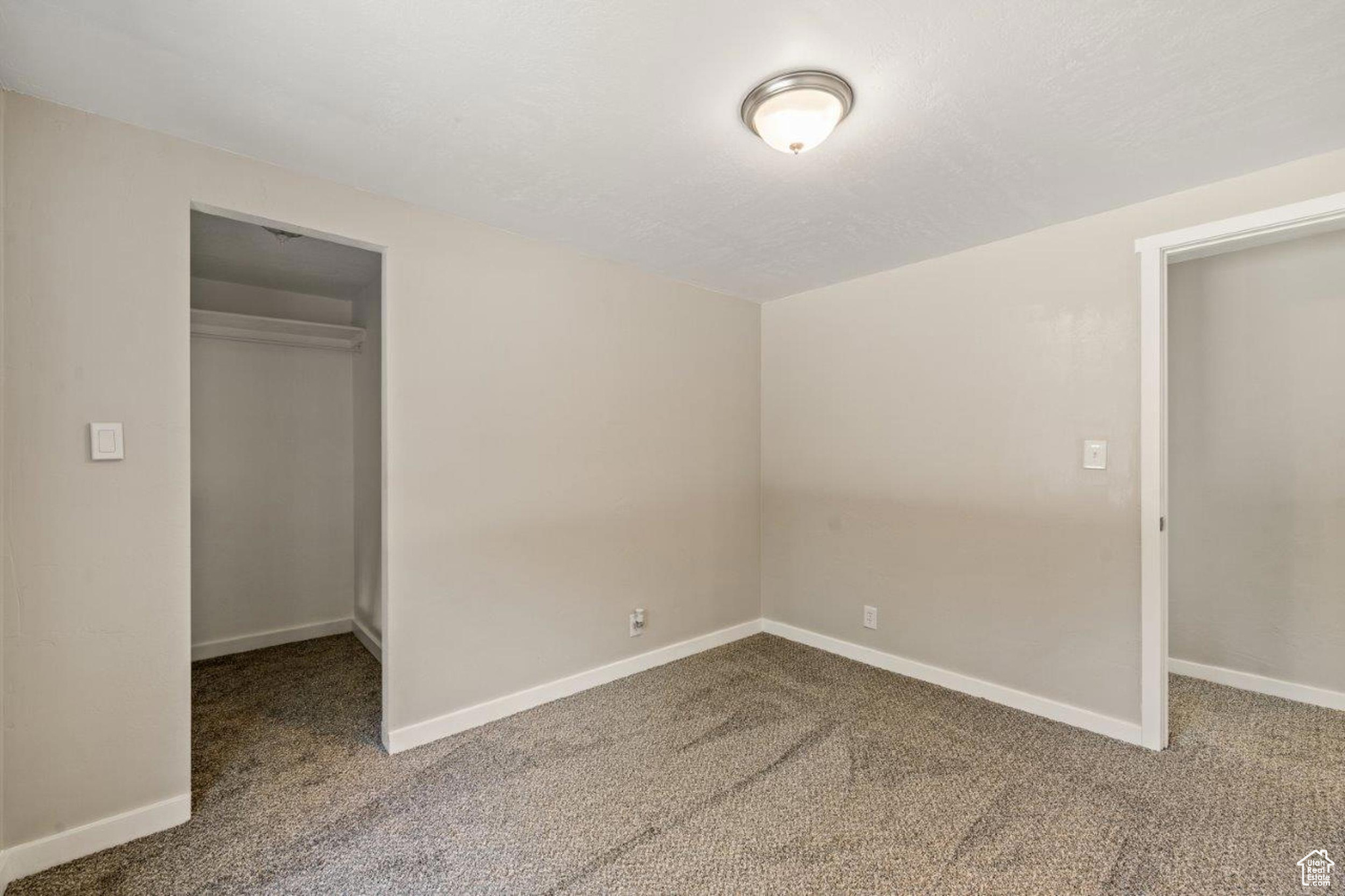 Unfurnished bedroom featuring carpet, a closet, and a spacious closet