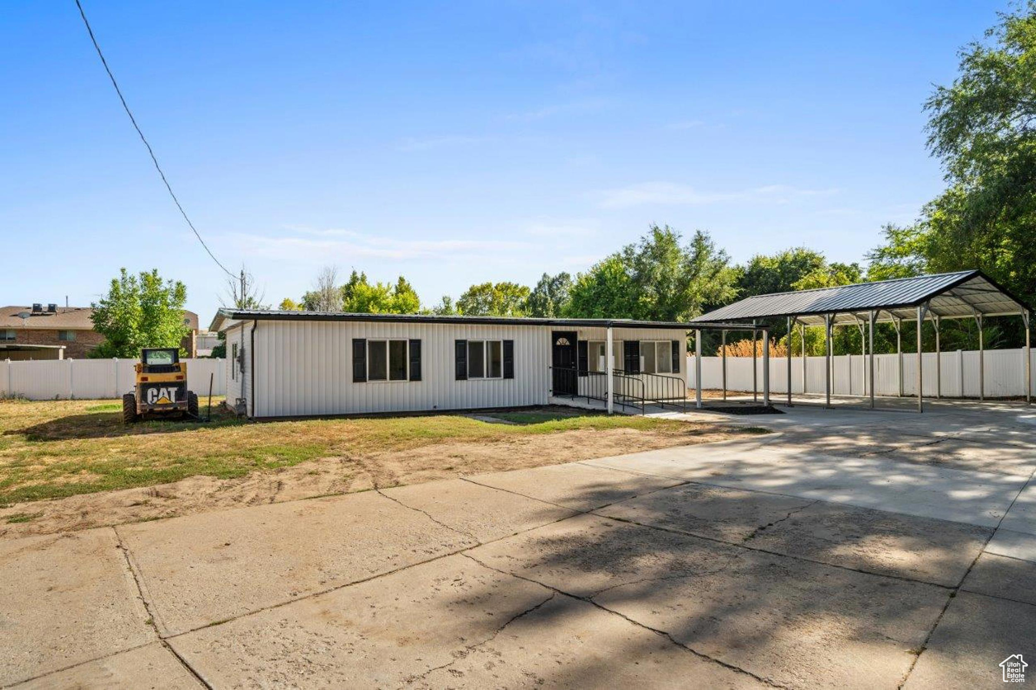 Back of house with a carport and a yard