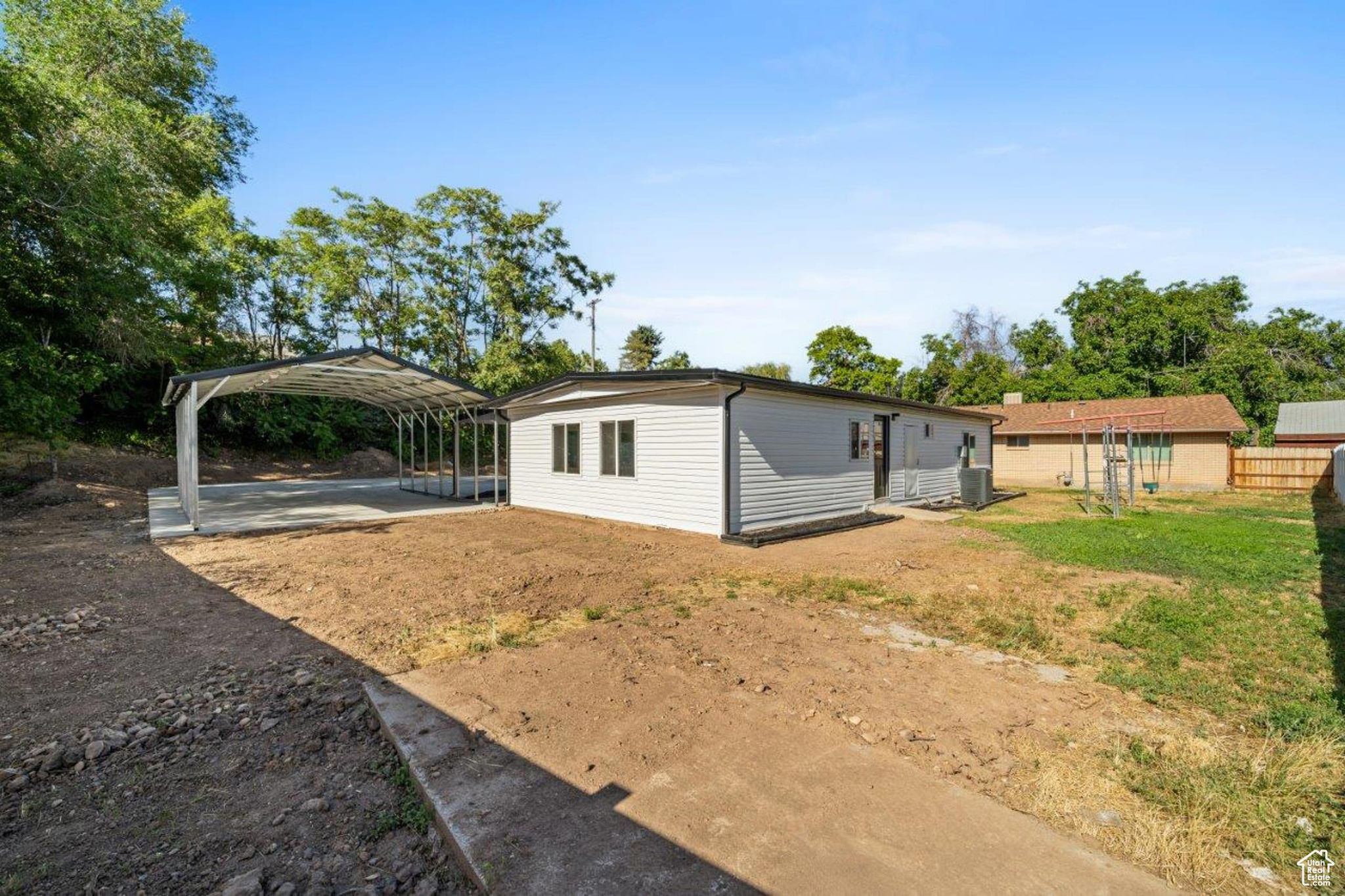 View of yard featuring central air condition unit and a carport