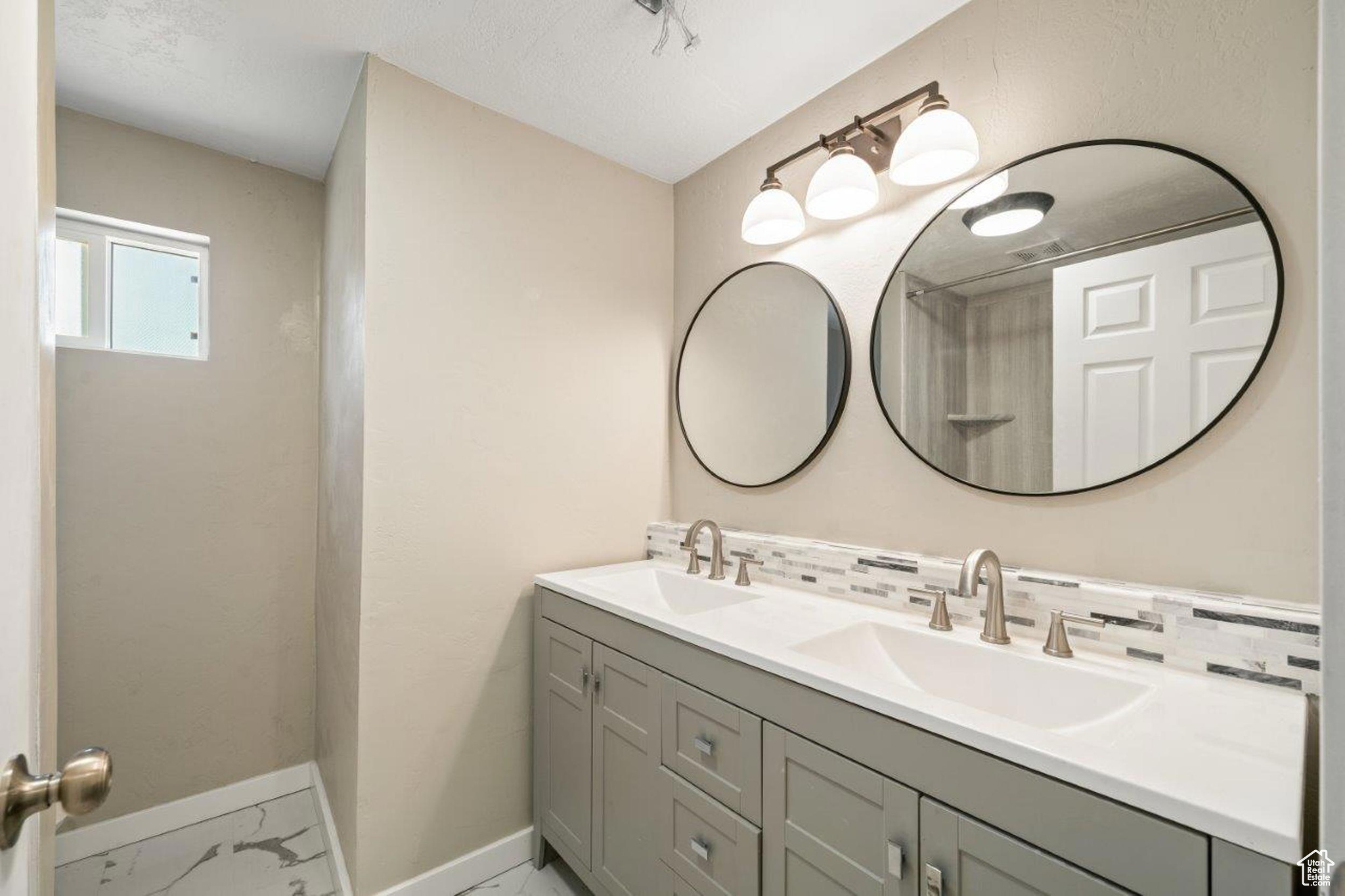 Bathroom with double vanity, decorative backsplash, and tile patterned floors