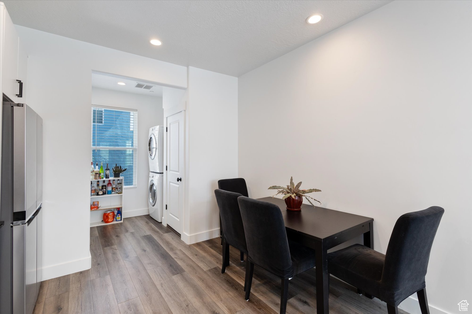 Dining space featuring stacked washer / dryer and light hardwood / wood-style flooring