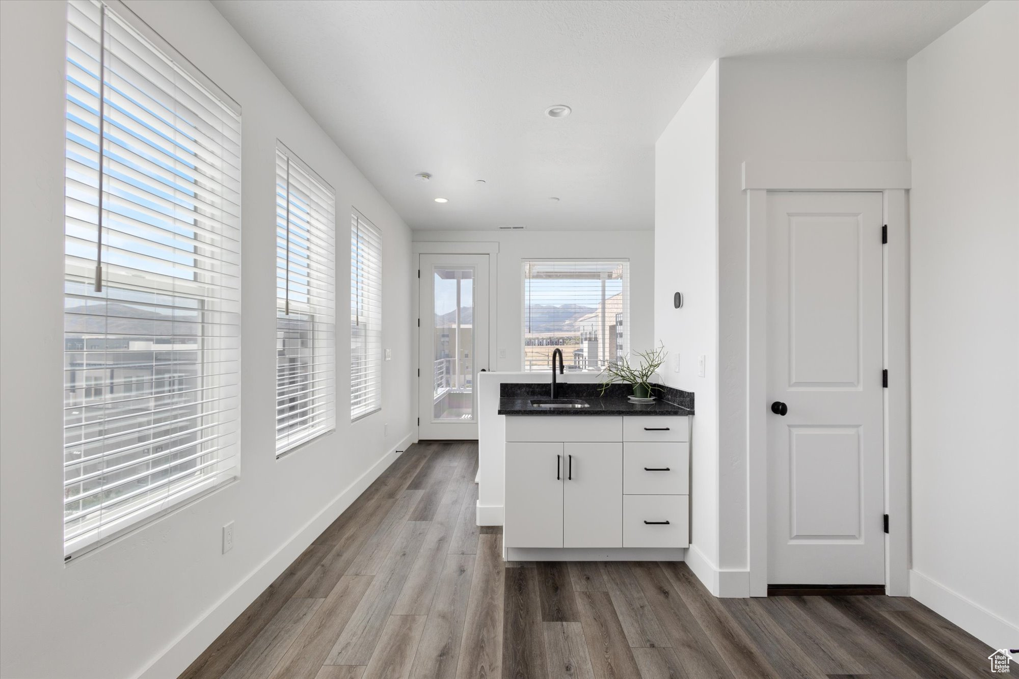 Kitchen featuring hardwood / wood-style flooring, sink, and white cabinets