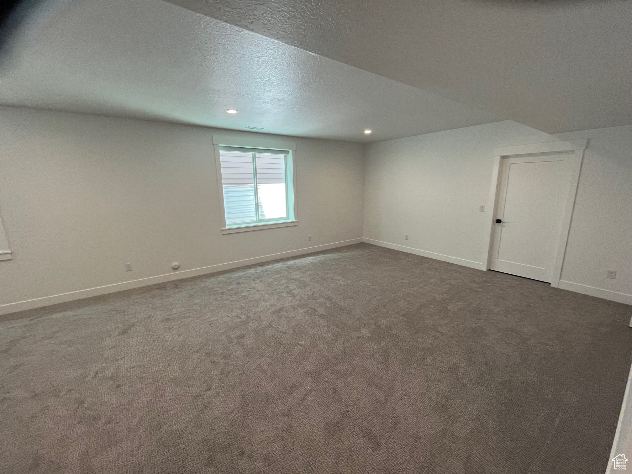 Spare room with a textured ceiling and carpet floors