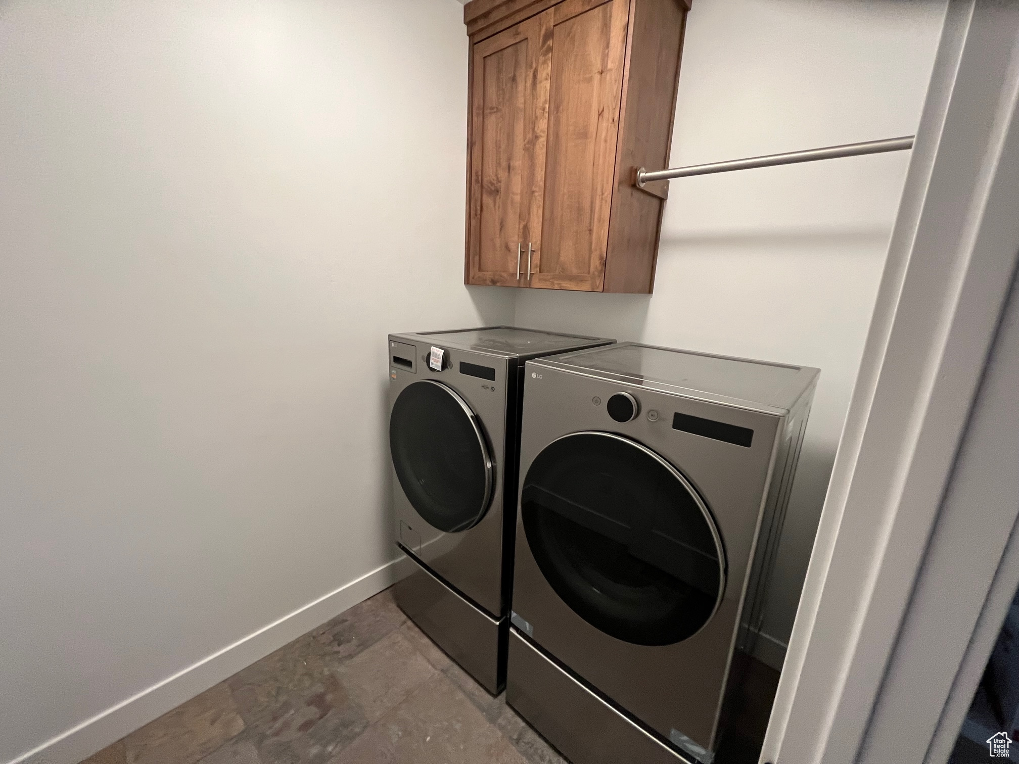 Laundry area featuring washing machine and clothes dryer, cabinets, and light tile patterned flooring