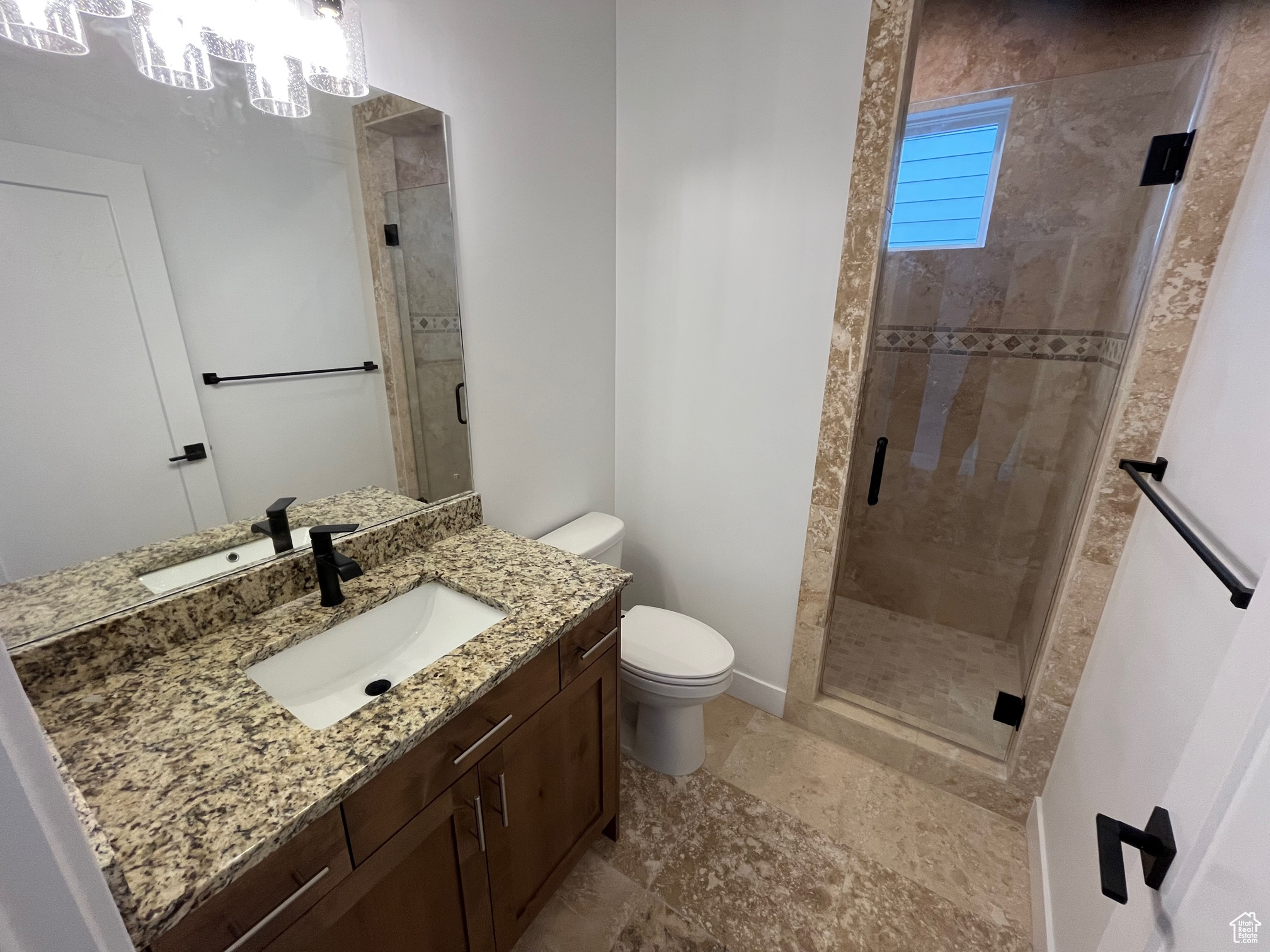 Bathroom with tile patterned flooring, toilet, vanity, and a shower with shower door