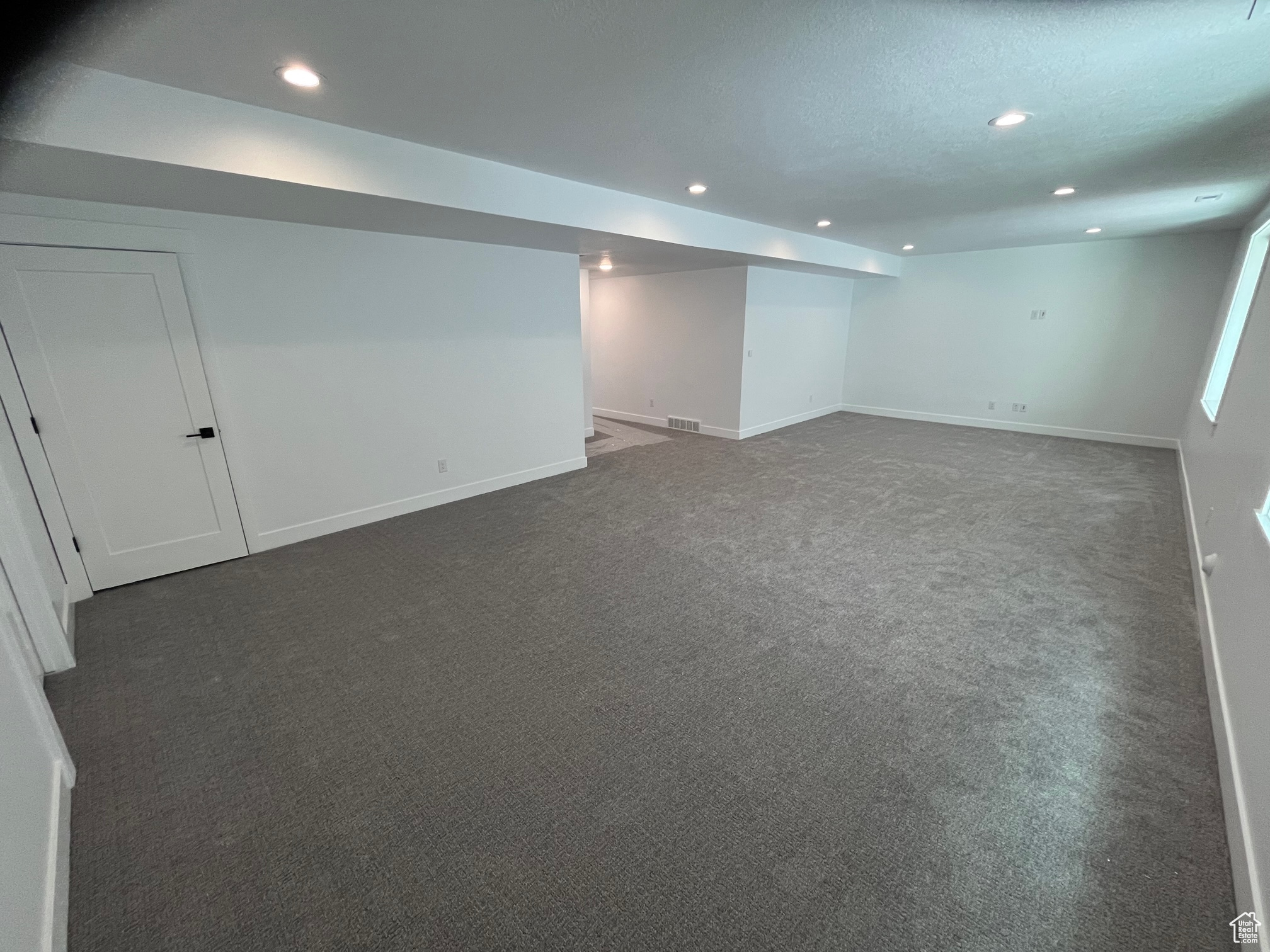 Basement with a textured ceiling and carpet flooring