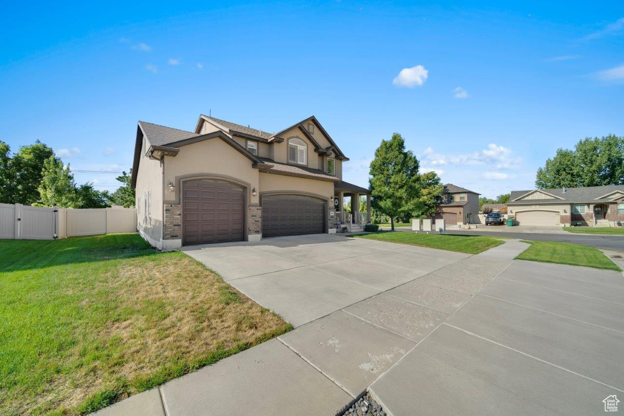 View of front facade featuring a front yard and a garage