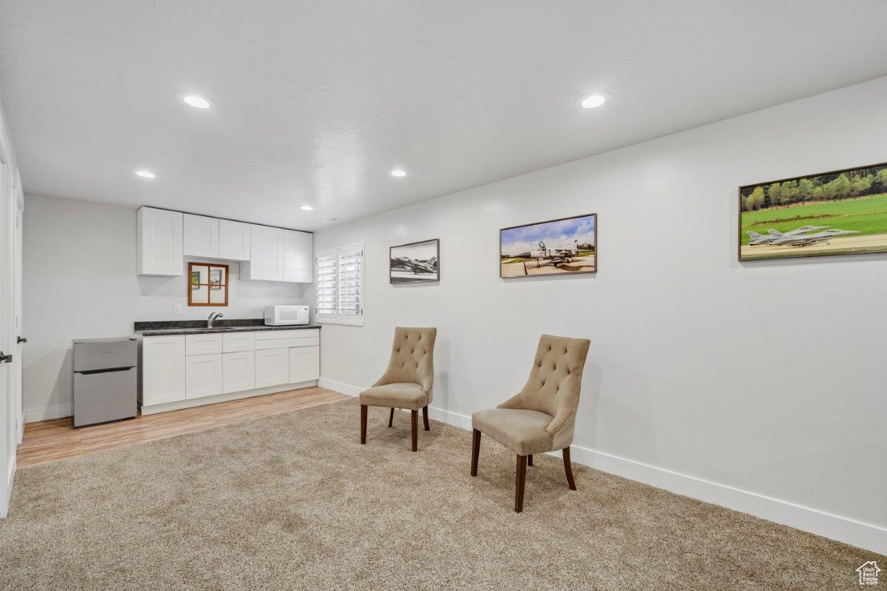 Sitting room featuring sink and light colored carpet