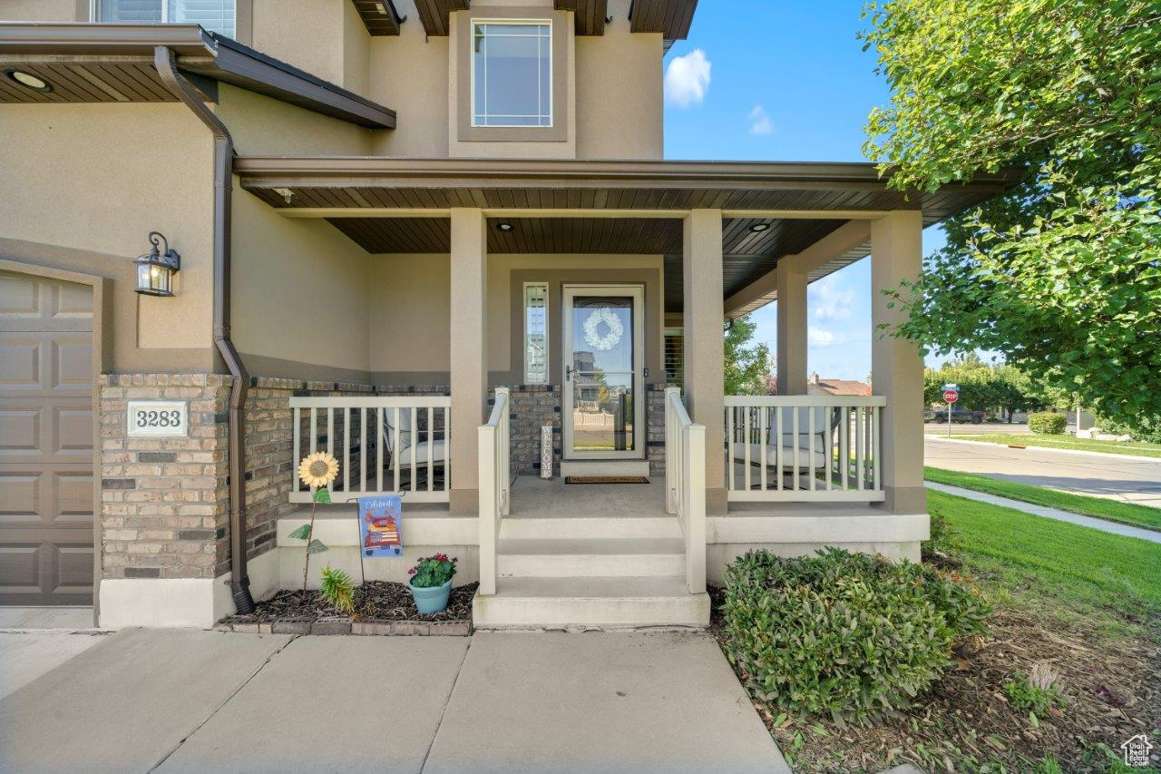 View of exterior entry featuring covered porch