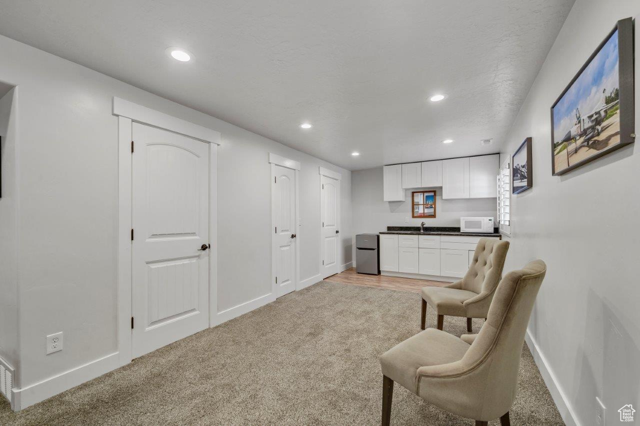 Sitting room featuring sink and light carpet