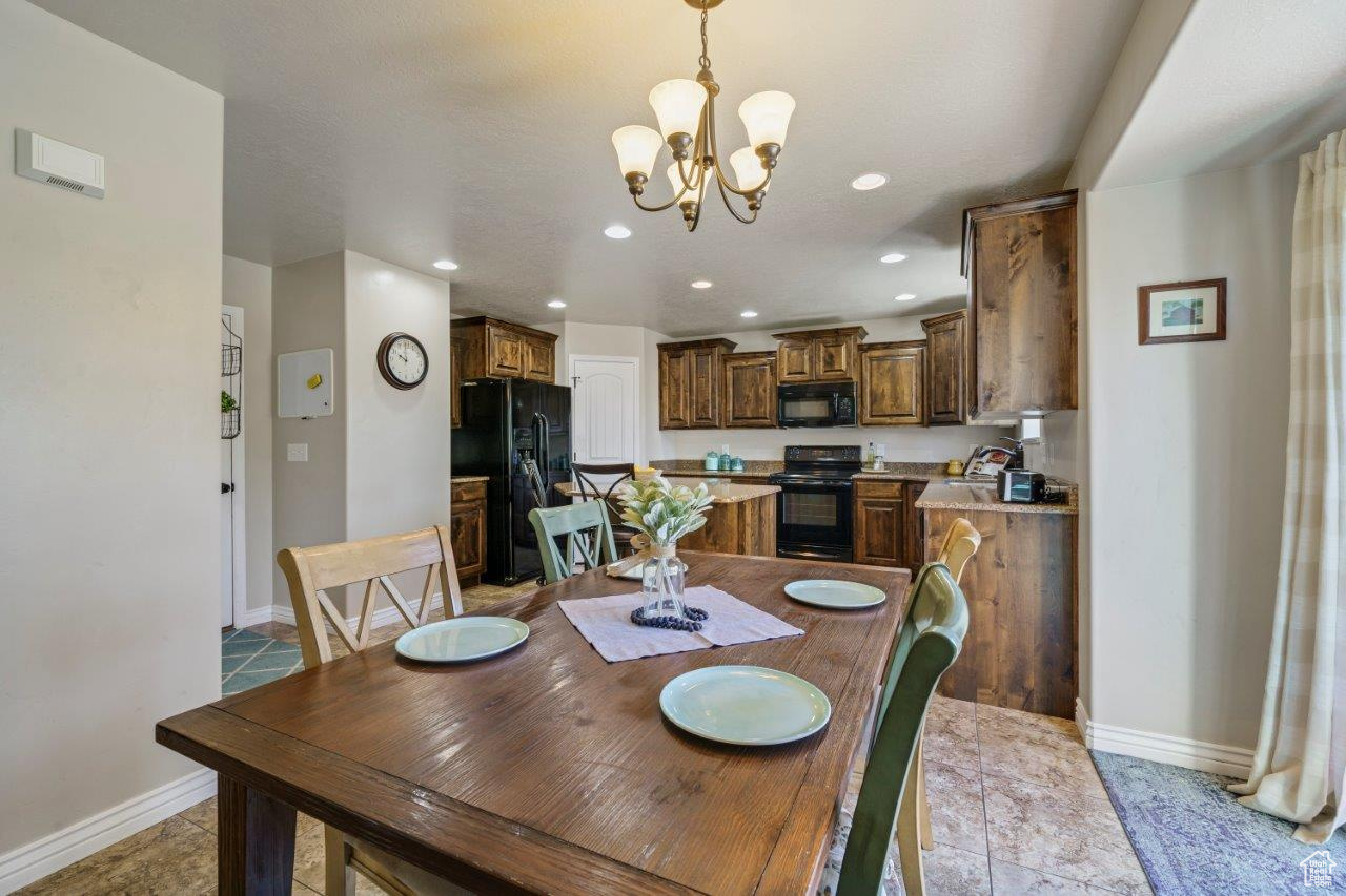 Dining room featuring sink, a chandelier, and light tile patterned floors