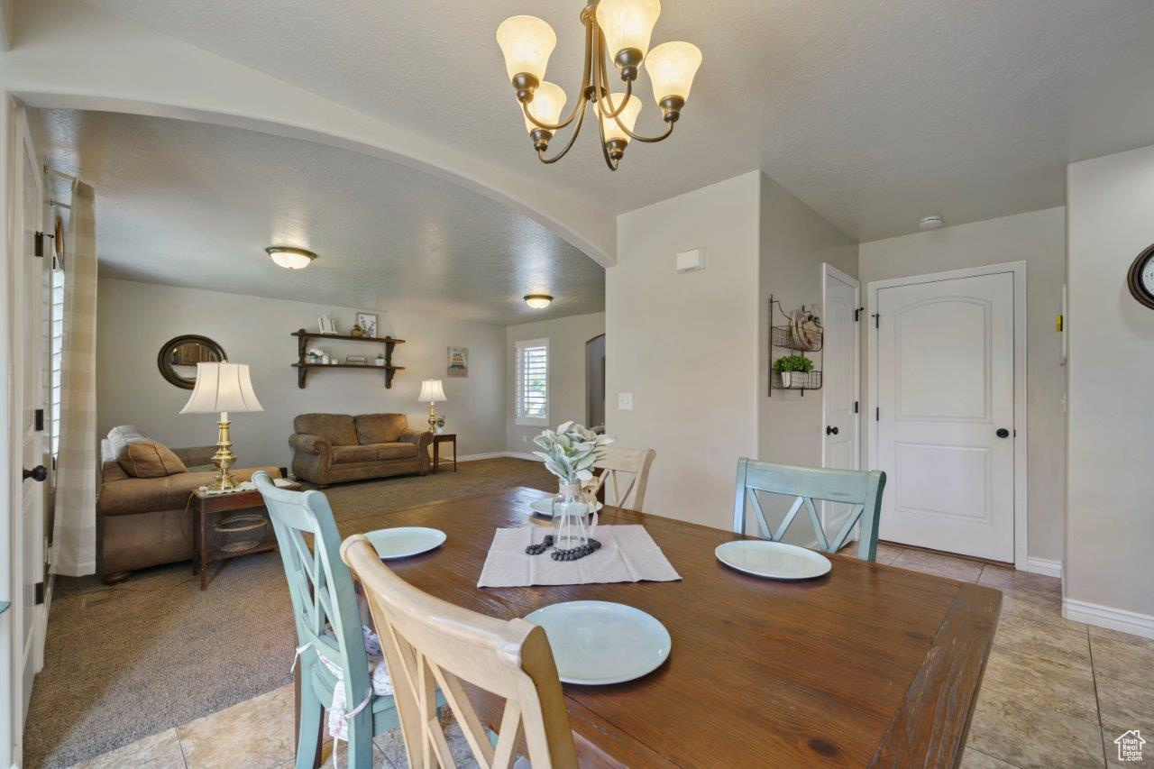 Carpeted dining area with a notable chandelier