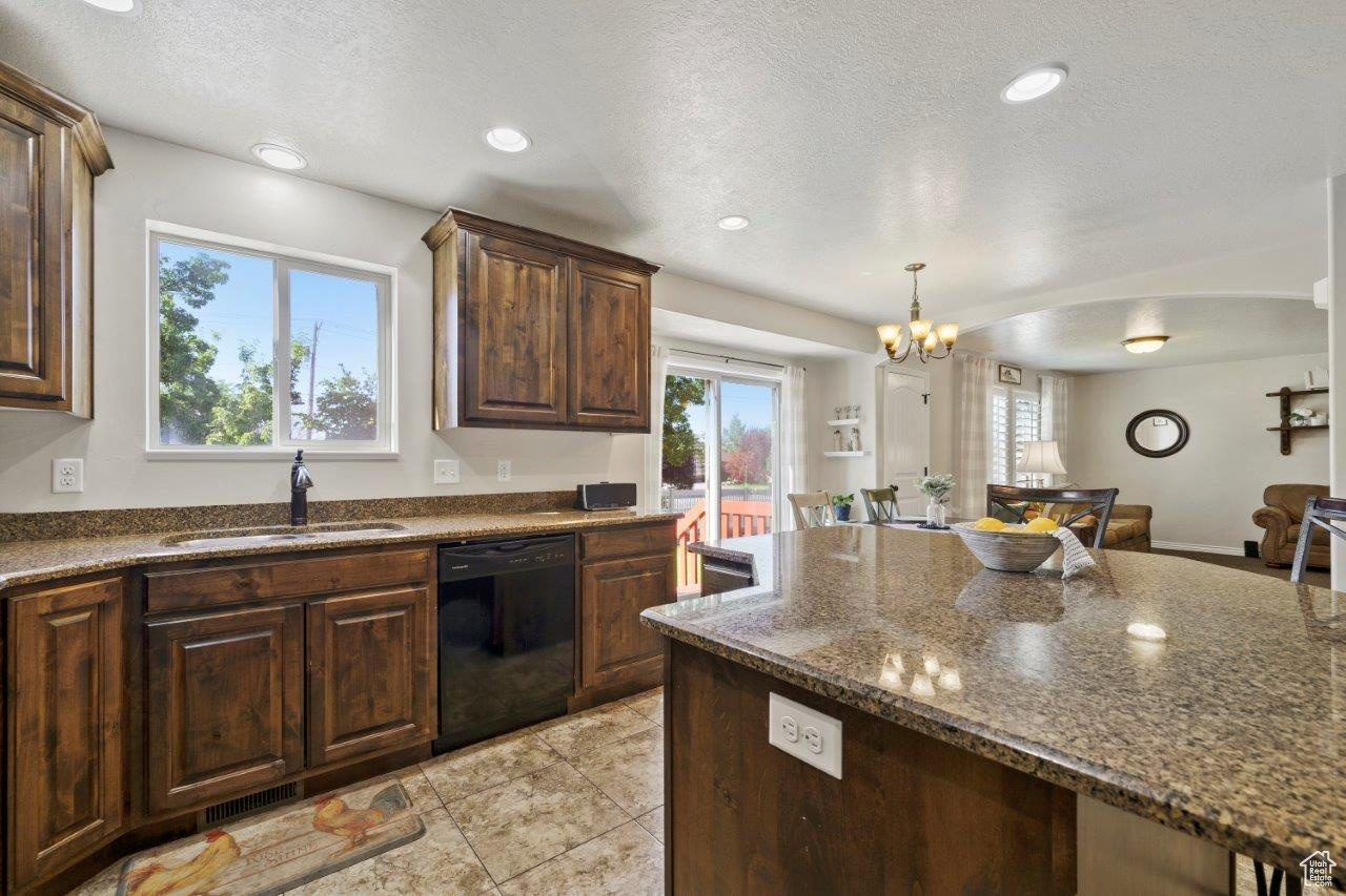 Kitchen with a wealth of natural light, sink, dishwasher, and light tile patterned floors