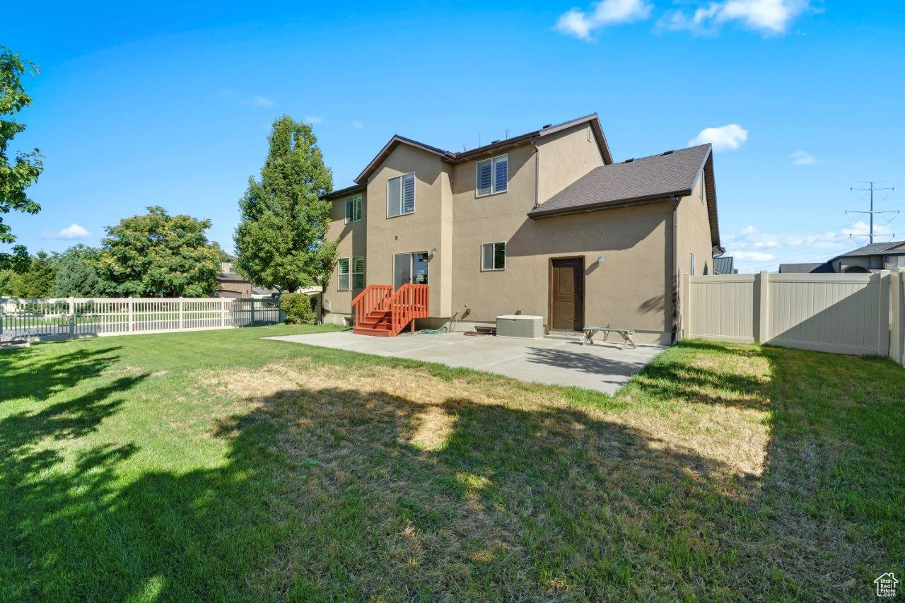 Rear view of property with a patio area and a lawn