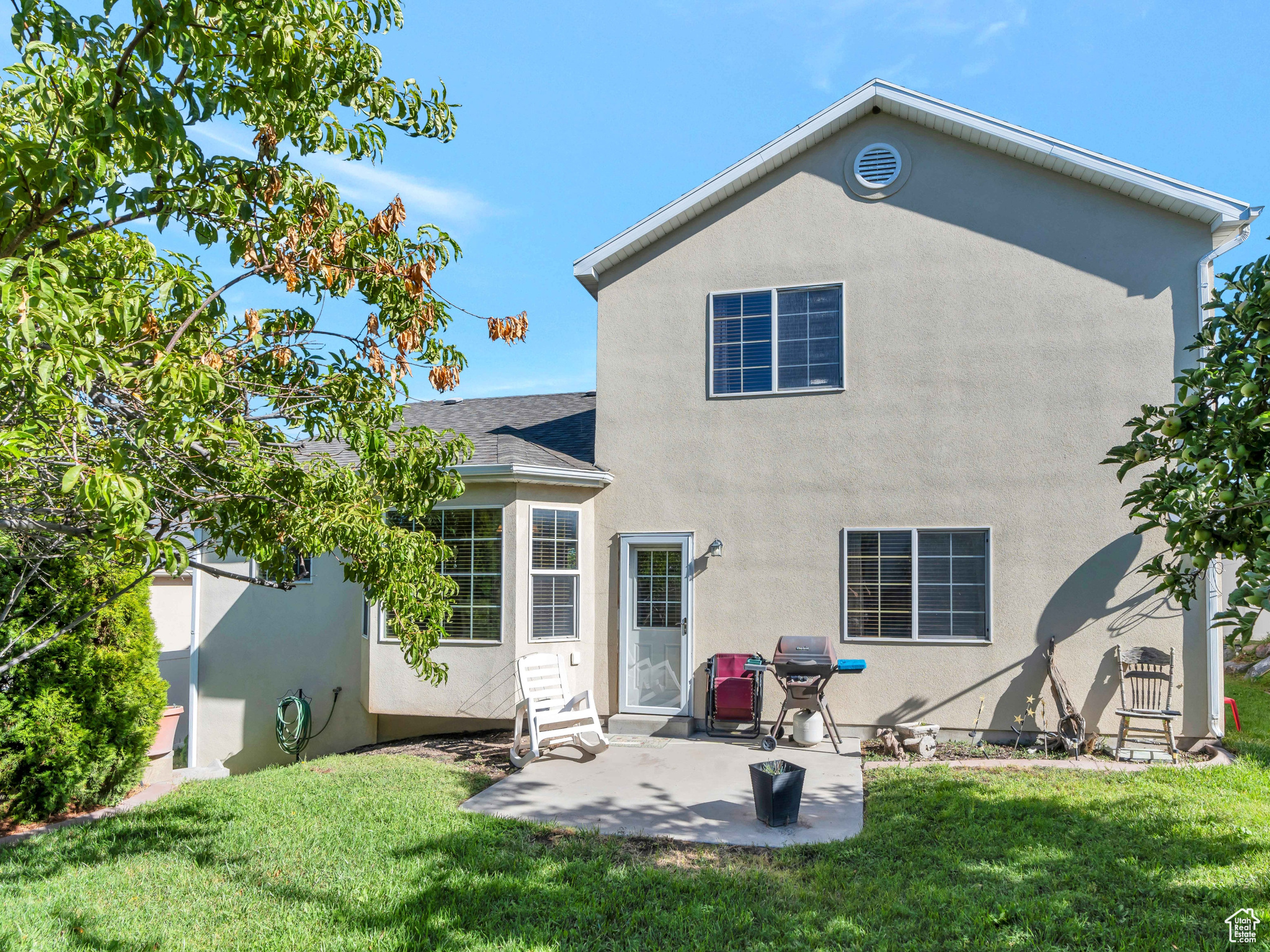 Rear view of house featuring a patio and a yard